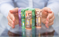 Hand Protecting Rolled Up Euro Banknote © apops - Fotolia