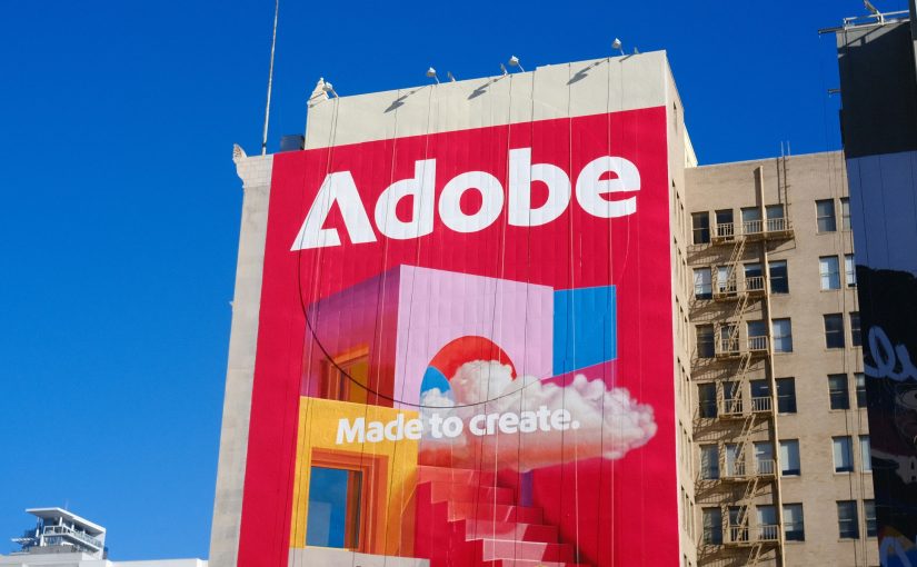 Huge Adobe banner with the slogan "Made to create." on a building facade against a blue sky